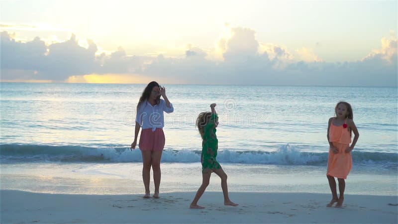 Mère et enfants appréciant des vacances tropicales d'été de plage Danse de famille sur la plage blanche Mouvement lent banque de vidéos