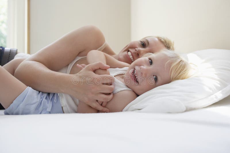 Mère et fille espiègles dans le lit images libres de droits