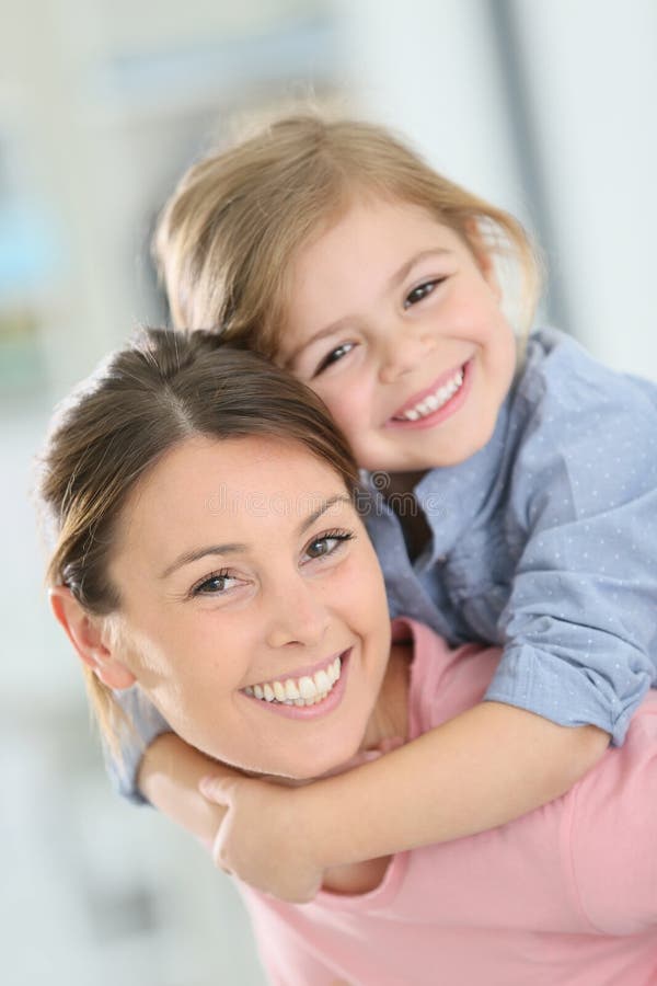 Mère et fille gaies sur elle de retour photo stock Mère et fille gaies sur elle de retour photo stock