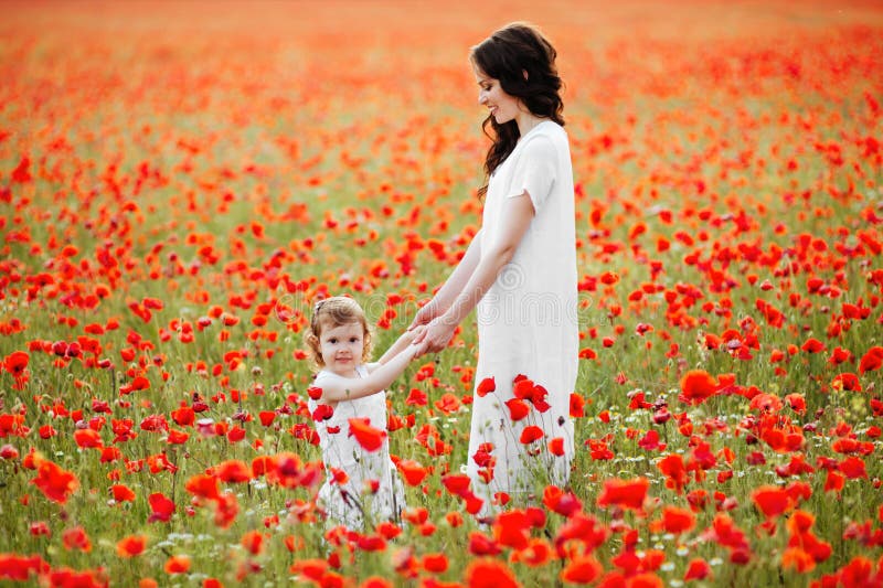 Mère et fille jouant dans le domaine de fleur photographie stock libre de droits Mère et fille jouant dans le domaine de fleur photographie stock libre de droits