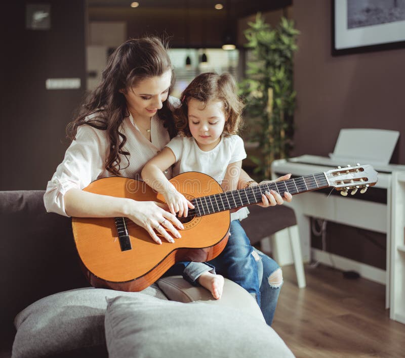 Mère et fille jouant une guitare photo stock Mère et fille jouant une guitare photo stock