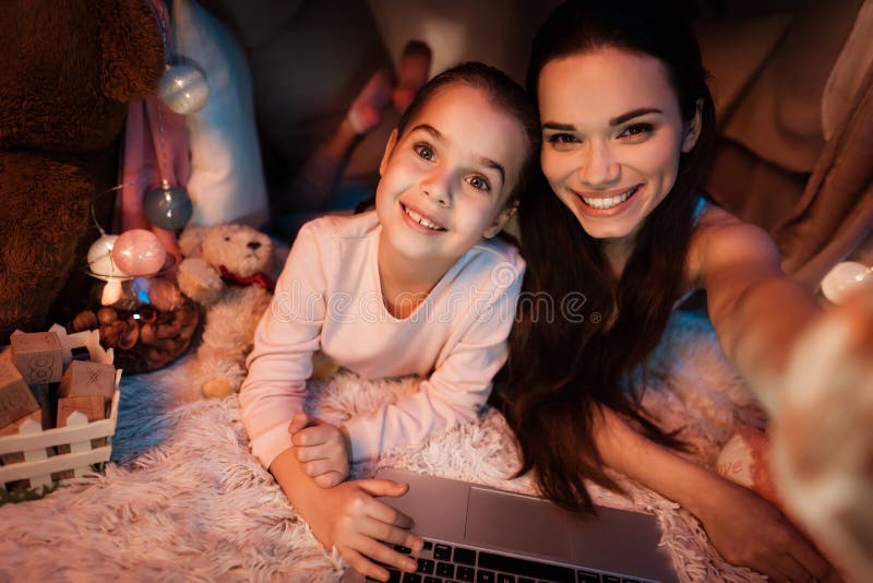 Mère et fille prenant le selfie dans la maison d'oreiller tard la nuit à la maison photographie stock Mère et fille prenant le selfie dans la maison d'oreiller tard la nuit à la maison photographie stock