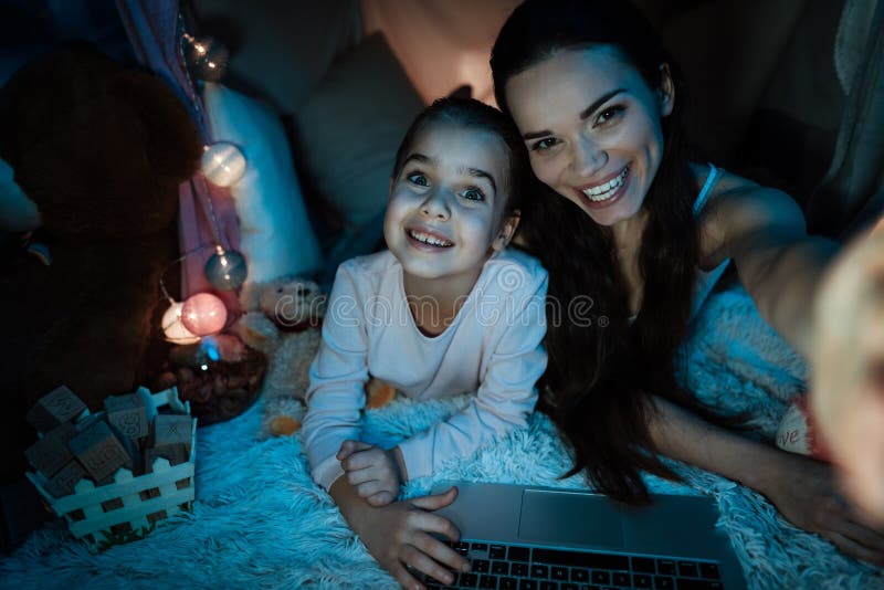 Mère et fille prenant le selfie dans la maison d'oreiller tard la nuit à la maison photos stock Mère et fille prenant le selfie dans la maison d'oreiller tard la nuit à la maison photos stock