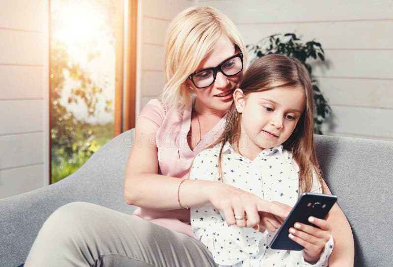 Mère et fille à l'aide du téléphone portable photo libre de droits Mère et fille à l'aide du téléphone portable photo libre de droits