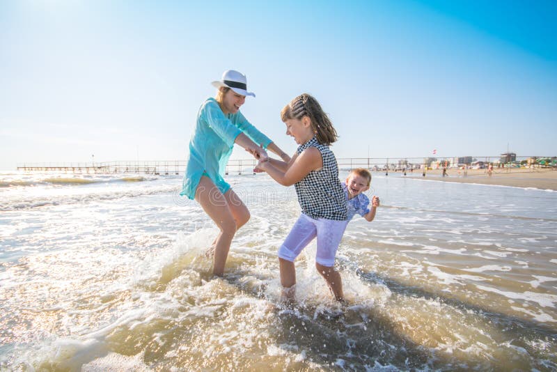 Mère et ses enfants jouant en mer image stock Mère et ses enfants jouant en mer image stock