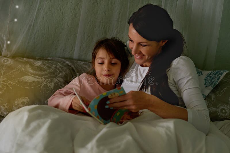 Mère fille et livre d'histoire dans le lit amour et la littérature pour le coucher et se détendre à la maison. fille maman et ense photo stock