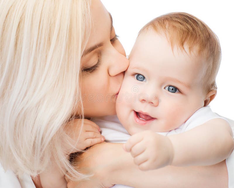 Mère heureuse embrassant le bébé de sourire image stock Mère heureuse embrassant le bébé de sourire image stock