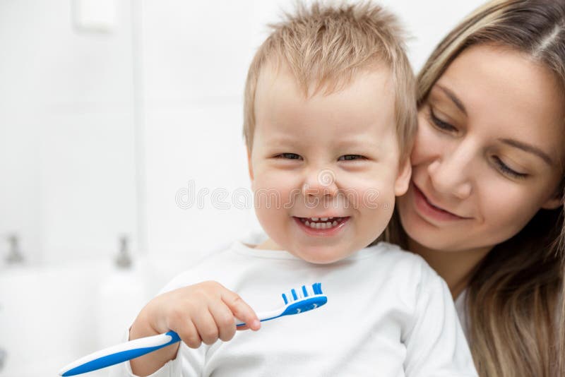 Mère heureuse enseignant à son fils comment baguer des dents images libres de droits