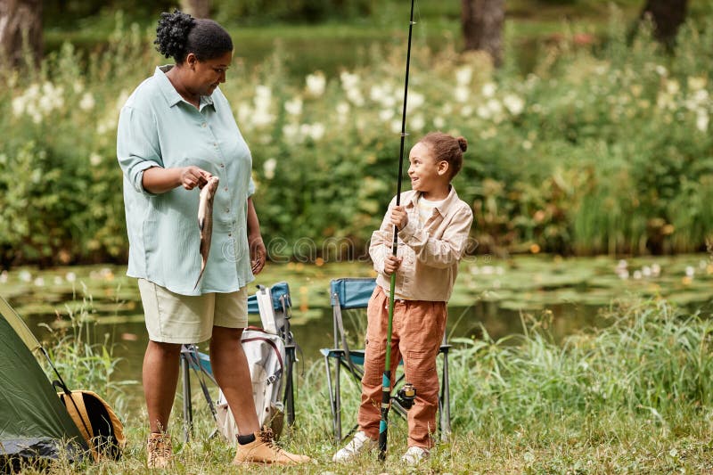 Mère heureuse et fille pêchent ensemble pendant le camping photographie stock libre de droits