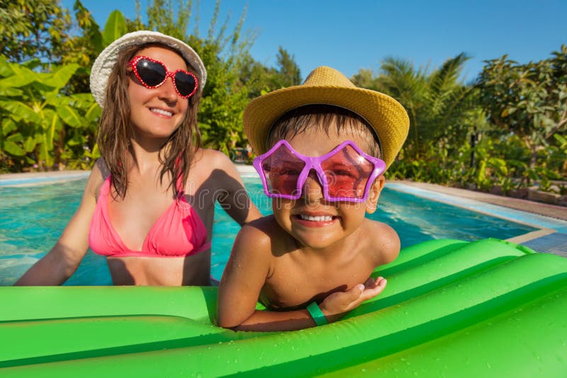 Mère heureuse et garçon utilisant les lunettes de soleil drôles photographie stock Mère heureuse et garçon utilisant les lunettes de soleil drôles photographie stock
