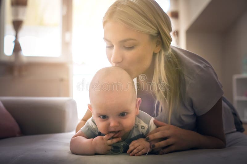 Mère heureuse sur le lit avec son petit bébé garçon à la maison photo libre de droits Mère heureuse sur le lit avec son petit bébé garçon à la maison photo libre de droits