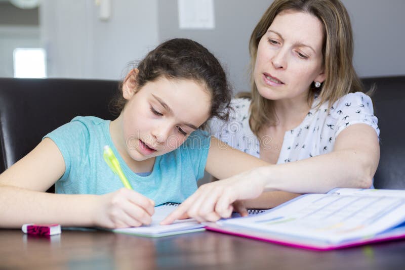 Mère mûre aidant son enfant avec des devoirs à la maison photographie stock libre de droits Mère mûre aidant son enfant avec des devoirs à la maison photographie stock libre de droits