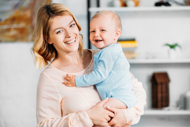 mère portant le petit enfant adorable et regardant la caméra photographie stock libre de droits mère portant le petit enfant adorable et regardant la caméra photographie stock libre de droits