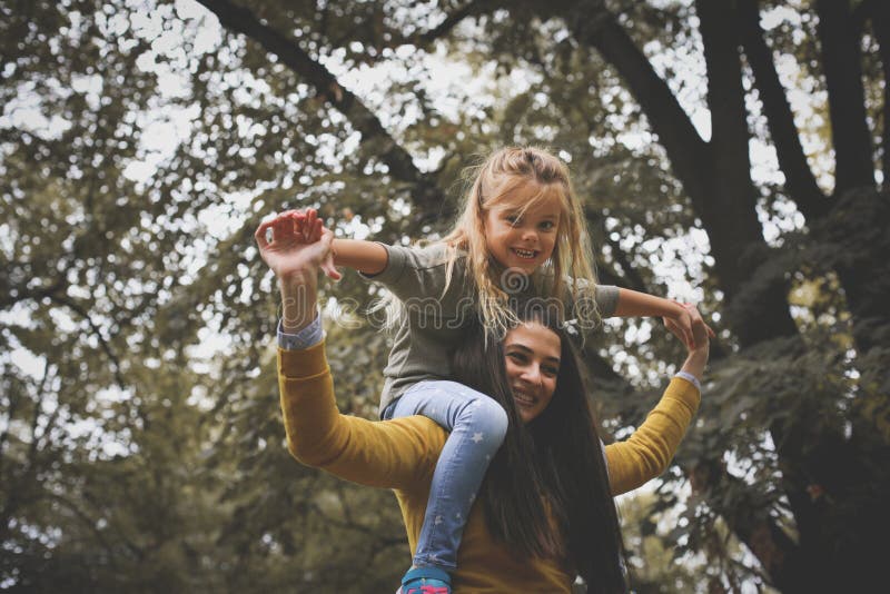 Mère portant sa petite fille sur des épaules photographie stock