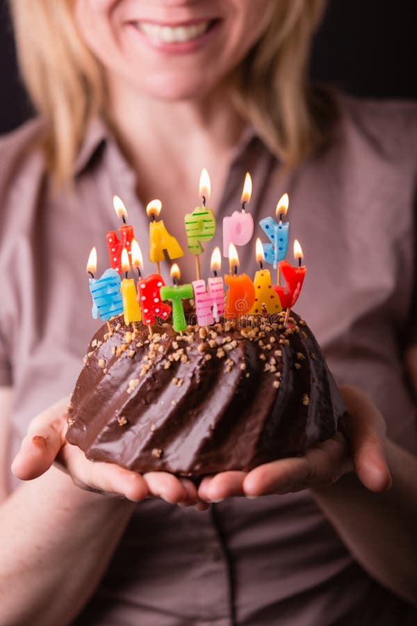 Mère tenant un gâteau d'anniversaire avec les bougies colorées Anniversaire, partie et concept de la famille photographie stock Mère tenant un gâteau d'anniversaire avec les bougies colorées Anniversaire, partie et concept de la famille photographie stock