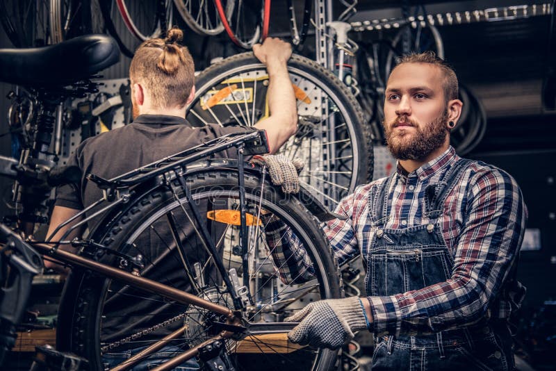 Mécanicien fixant le dérailleur arrière d'une bicyclette photographie stock