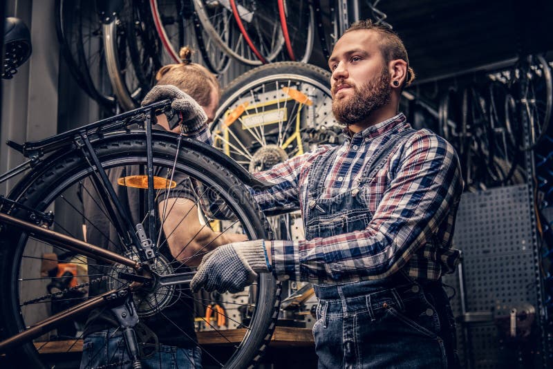 Mécanicien fixant le dérailleur arrière d'une bicyclette images stock