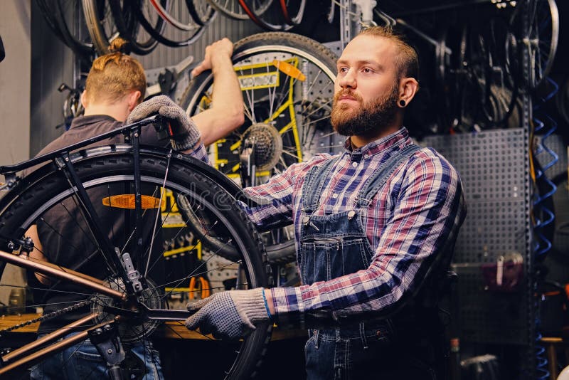 Mécanicien fixant le dérailleur arrière d'une bicyclette images stock