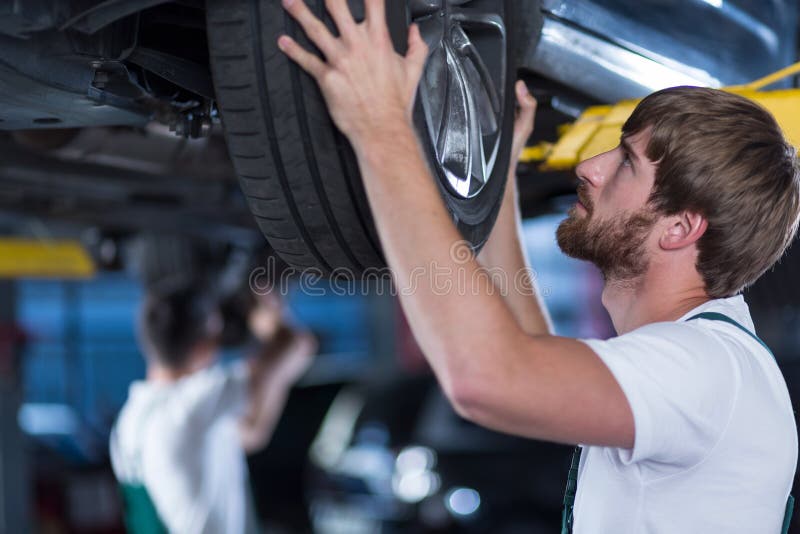 Close-up of automobile mechanics repairing a car. Close-up of automobile mechanics repairing a car