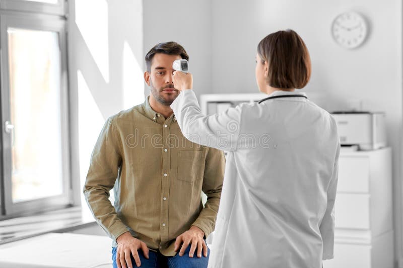 Médecin avec thermomètre et homme à l'hôpital photos stock