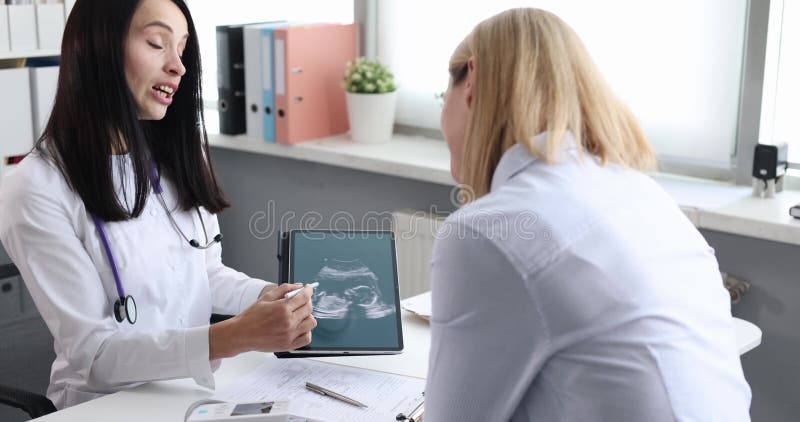 Médecin avec échographie partage des détails avec femme enceinte clips vidéos