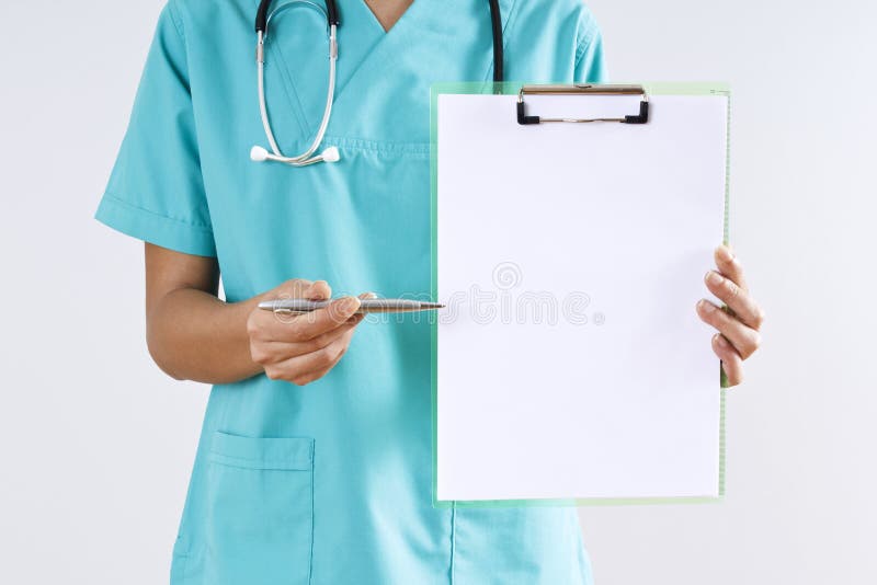 Médecin de femme indiquant par le stylo l'espace du presse-papiers sur le fond gris photo stock Médecin de femme indiquant par le stylo l'espace du presse-papiers sur le fond gris photo stock