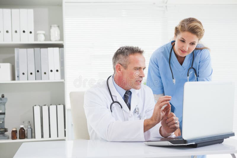 Médecin et infirmière regardant l'ordinateur portable