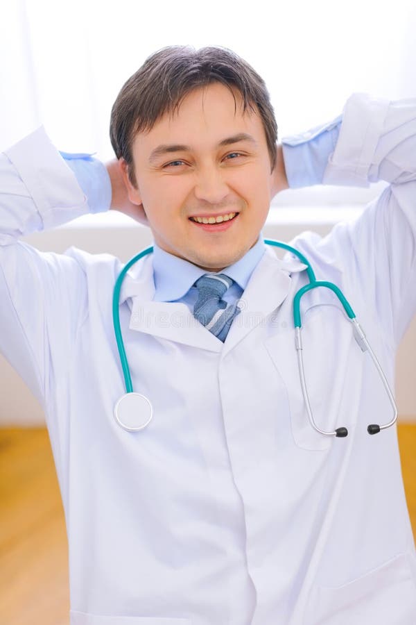 Médecin heureux détendant sur la présidence au bureau photos libres de droits Médecin heureux détendant sur la présidence au bureau photos libres de droits