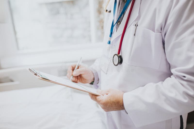 Médecin notant les symptômes d'un patient photos stock