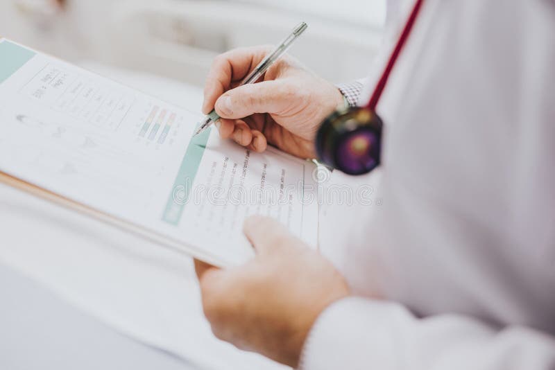 Médecin notant vers le bas des symptômes d'un patient photo libre de droits