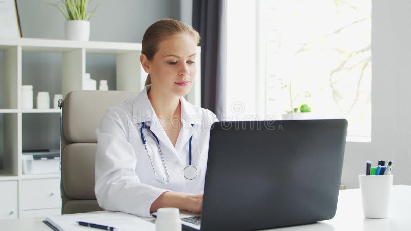 Médecin travaille au cabinet médical. femme en manteau blanc. lieu de travail d'une femme thérapeute professionnelle dans un hôpit clips vidéos