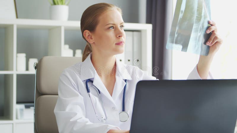 Médecin travaille au cabinet médical. femme en manteau blanc. lieu de travail d'une femme thérapeute professionnelle dans un hôpit banque de vidéos