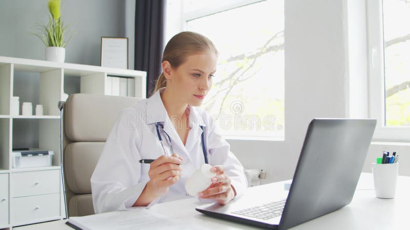 Médecin travaille au cabinet médical. femme en manteau blanc. lieu de travail d'une femme thérapeute professionnelle dans un hôpit banque de vidéos