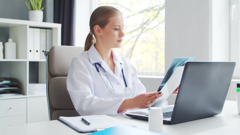 Médecin travaille au cabinet médical. femme en manteau blanc. lieu de travail d'une femme thérapeute professionnelle dans un hôpit banque de vidéos