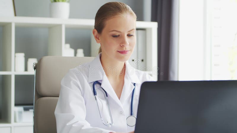 Médecin travaille au cabinet médical. femme en manteau blanc. lieu de travail d'une femme thérapeute professionnelle dans un hôpit banque de vidéos