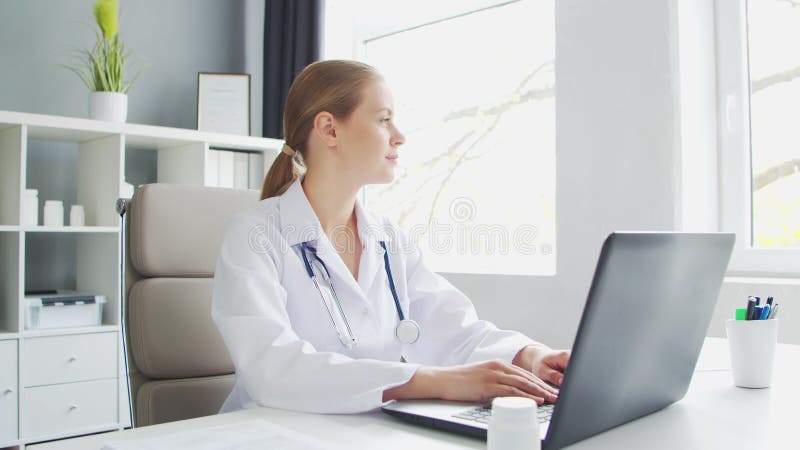 Médecin travaille au cabinet médical. femme en manteau blanc. lieu de travail d'une femme thérapeute professionnelle dans un hôpit banque de vidéos