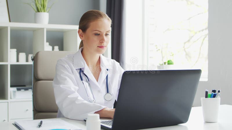 Médecin travaille au cabinet médical. femme en manteau blanc. lieu de travail d'une femme thérapeute professionnelle dans un hôpit banque de vidéos