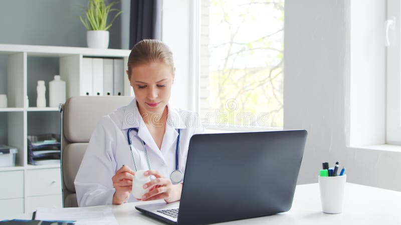 Médecin travaille au cabinet médical. femme en manteau blanc. lieu de travail d'une femme thérapeute professionnelle dans un hôpit banque de vidéos