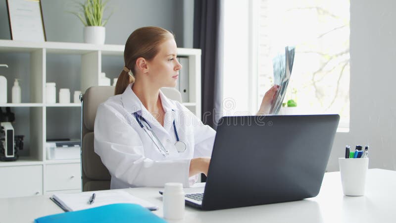 Médecin travaille au cabinet médical. femme en manteau blanc. lieu de travail d'une femme thérapeute professionnelle dans un hôpit banque de vidéos