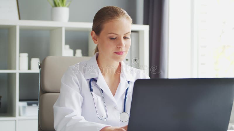 Médecin travaille au cabinet médical. femme en manteau blanc. lieu de travail d'une femme thérapeute professionnelle dans un hôpit clips vidéos