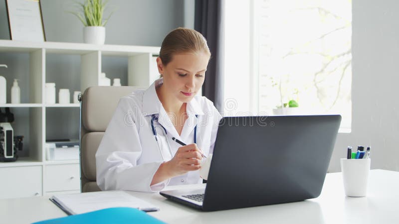 Médecin travaille au cabinet médical. femme en manteau blanc. lieu de travail d'une femme thérapeute professionnelle dans un hôpit clips vidéos