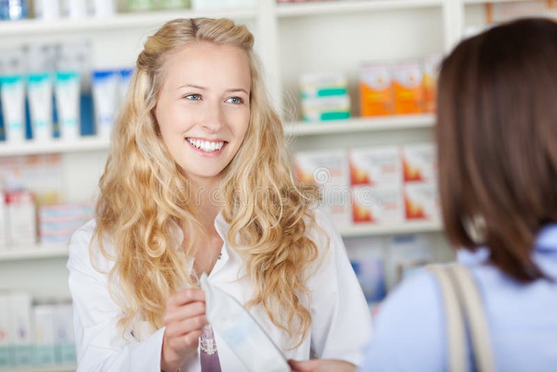 Médecine de Giving Bag Of de pharmacien au client image stock Médecine de Giving Bag Of de pharmacien au client image stock