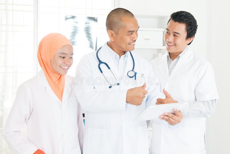 Médecins discutant sur le PC et les pouces de comprimé image libre de droits Médecins discutant sur le PC et les pouces de comprimé image libre de droits