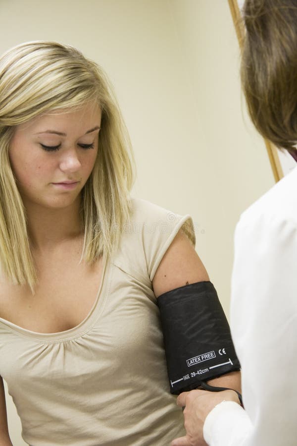 Médico caucasiano a examinar uma paciente adolescente fotografia de stock royalty free