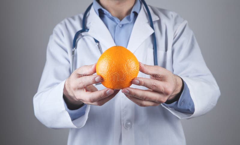Médico caucasiano a mostrar laranja foto de stock royalty free