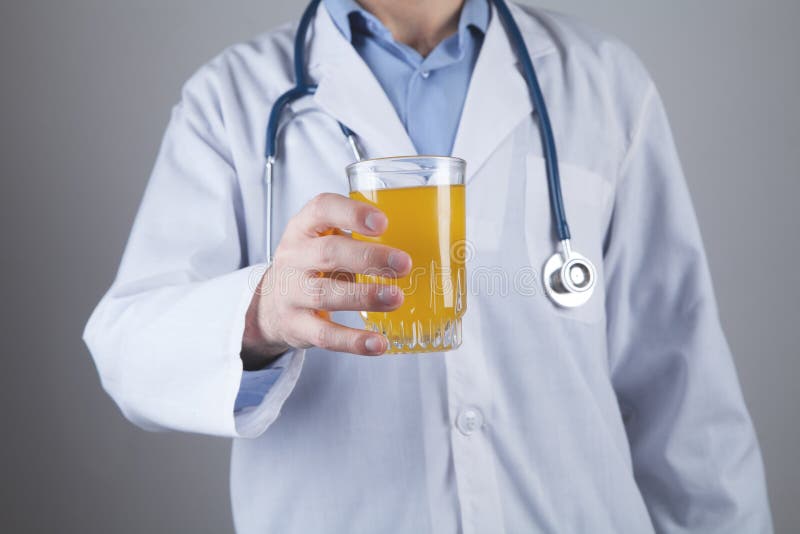 Médico caucasiano a mostrar vidro de sumo foto de stock