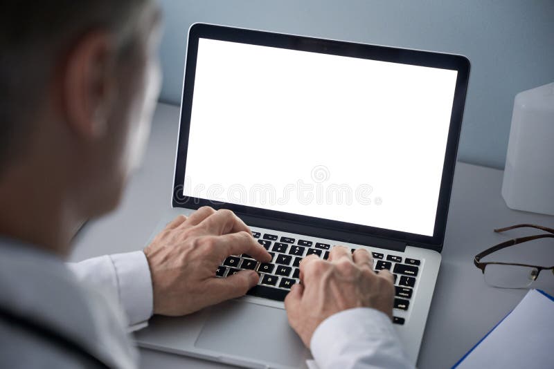 Male doctor using laptop computer with blank white mockup screen technology for tele medicine medical healthcare tech website ad concept, video call e telehealth online appointment. Over shoulder view. Male doctor using laptop computer with blank white mockup screen technology for tele medicine medical healthcare tech website ad concept, video call e telehealth online appointment. Over shoulder view