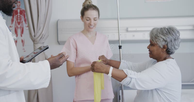 Médico masculino diverso con tablet y fisioterapeuta hembra con cámara lenta de paciente femenino de mayor edad metrajes