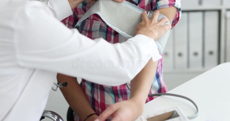 Médico mede a pressão arterial do doente no filme clínico 4k