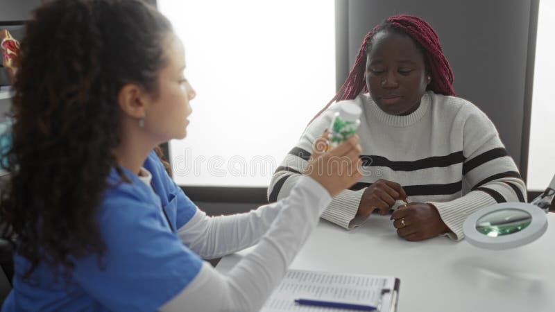 Médico mostrando medicación a paciente afroamericano en la sala de consultas de salud metrajes